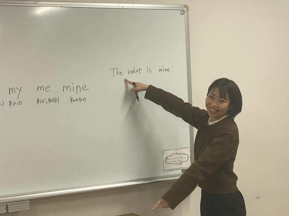 講師がホワイトボードで英語を説明している様子